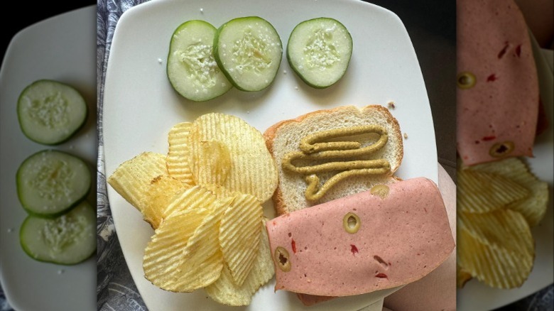 Slices of olive loaf lunch meat on a white background