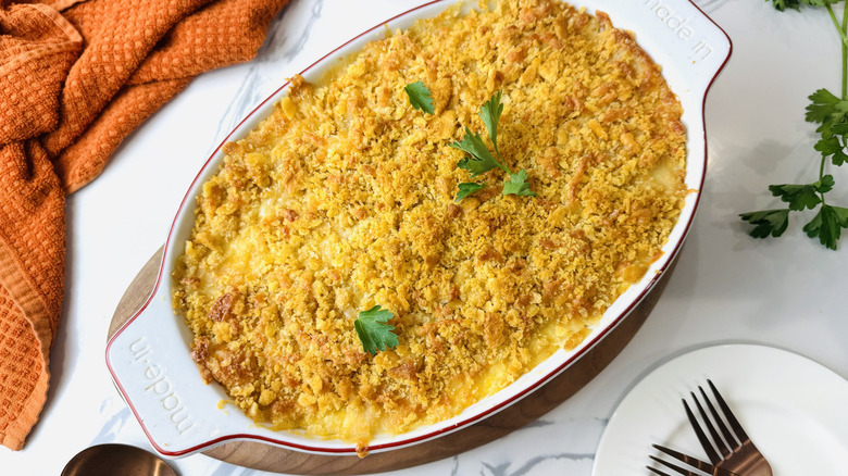 Corn casserole with cracker crumb topping in oval baking dish