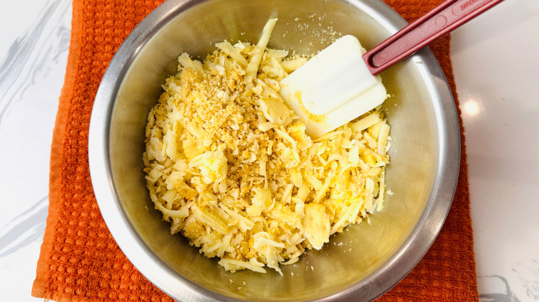 Crushed crackers and shredded cheese in bowl