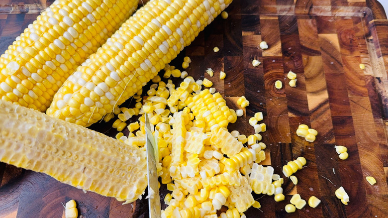 Knife cutting corn kernels off cob