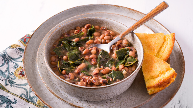 High angle view of US southern dish of black-eyed peas and collard greens with two slices of corn bread