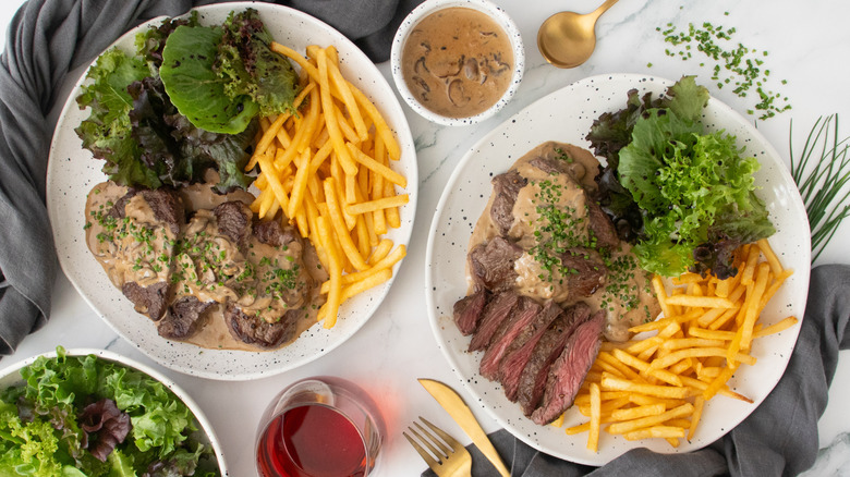 Overhead shot of Steak Diane with frites and salad