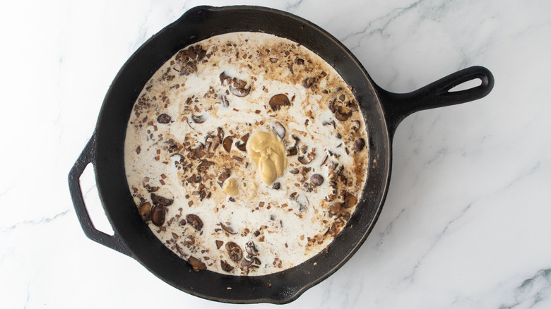 Skillet with cream, mustard, and sauteed mushrooms