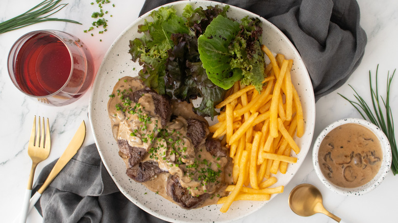 Plated Steak Diane with side salad and frites