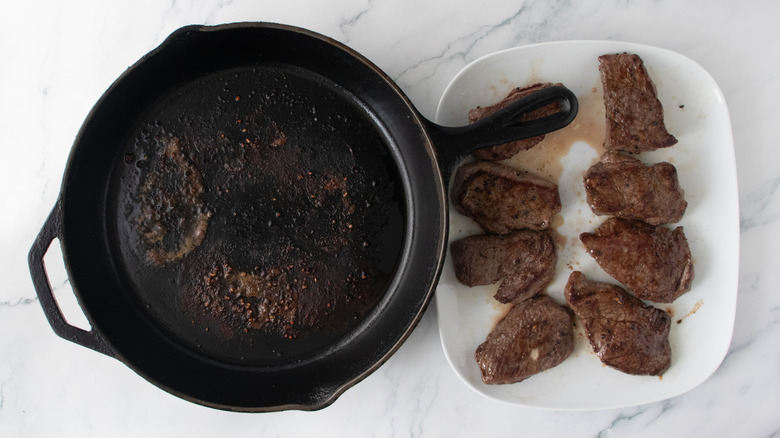 Seared steaks set aside on large platter