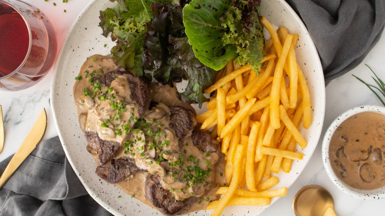 Close up Steak Diane with frites and salad