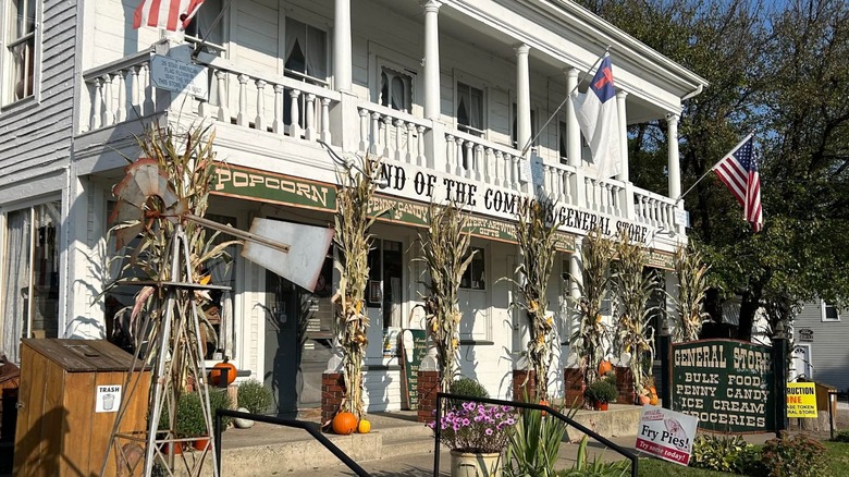 Exterior of the End of the Commons General Store's white building with flags