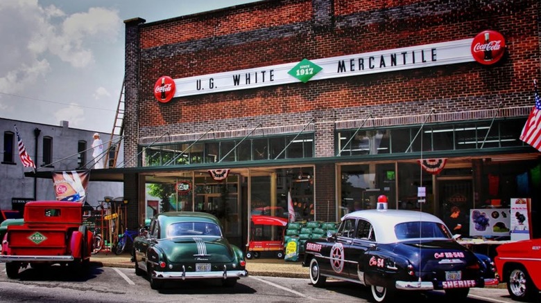 Exterior of the UG White Mercantile's brick building with vintage cars