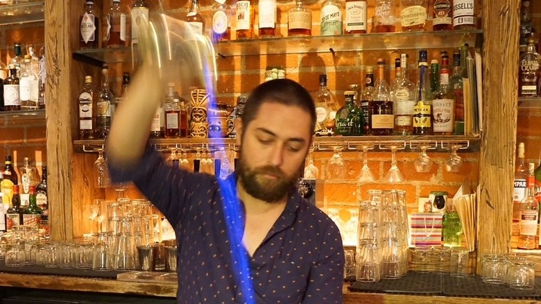 Bartender Liam Odien making a Blue Blazer