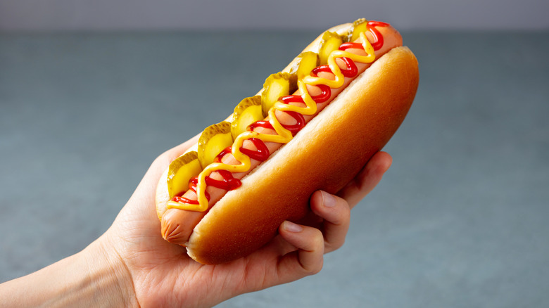 Hot dog on a bun with kethcup, mustard, and pickles
