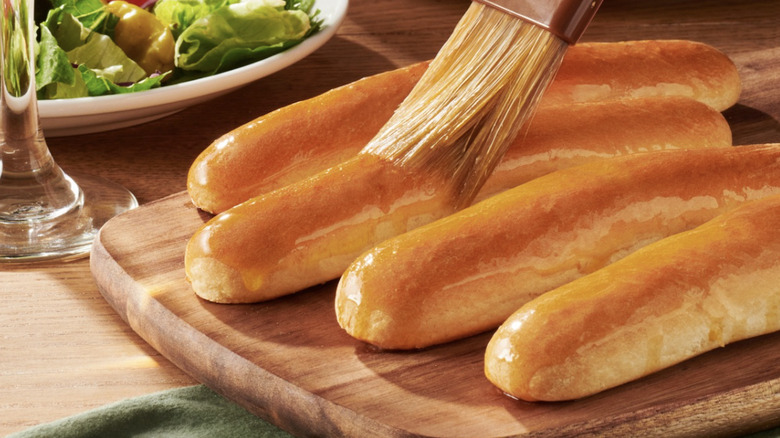 Olive Garden breadsticks being brushed with butter