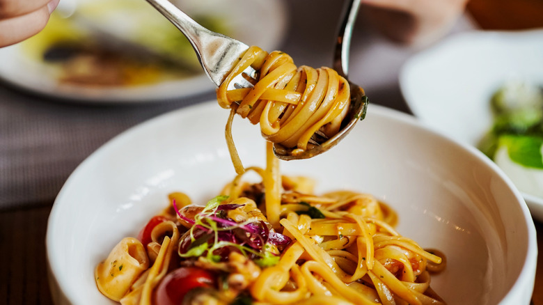 fork full of pasta over a bowl of spaghetti