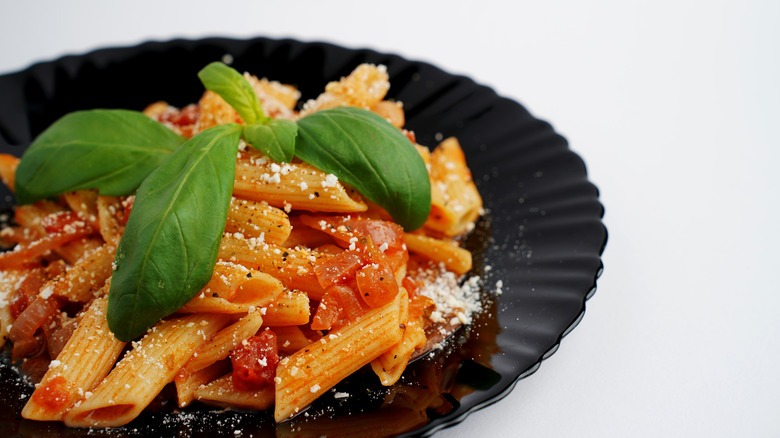 Pasta with tomato olive oil cheese and herbs.
