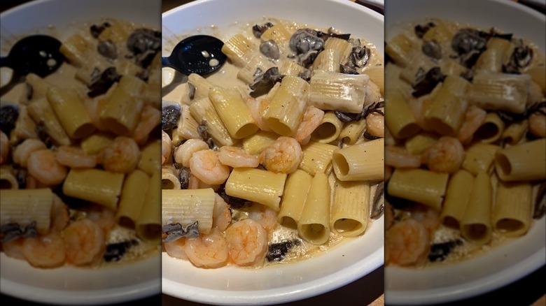 girl eats Italian pasta with tomato, meat. Close-up spaghetti Bolognese wind it around a fork with a spoon. Parmesan cheese.