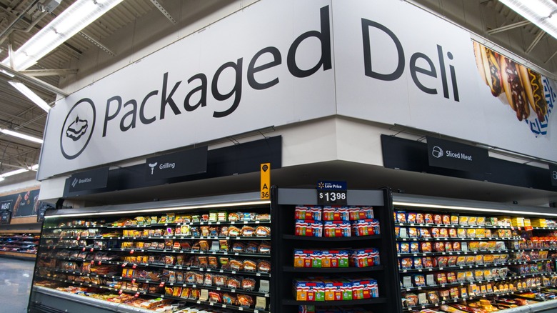 A grocery store's packaged deli section has many packaged lunch meat varieties