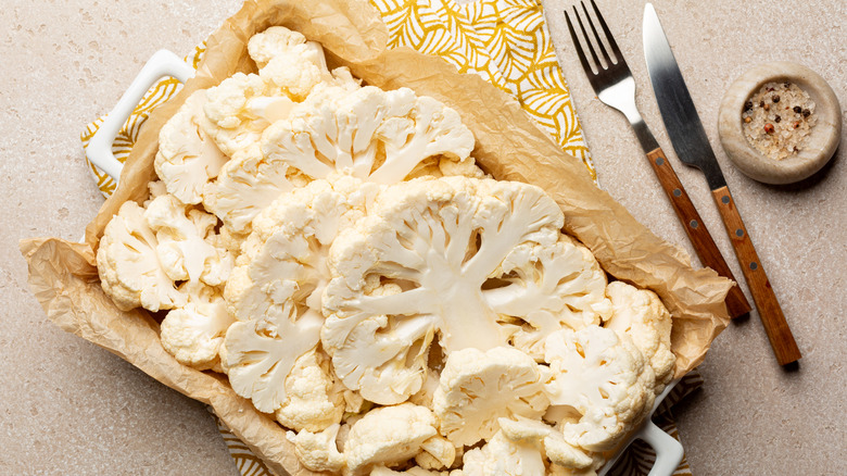 Cauliflower steak slices sit in a casserole dish