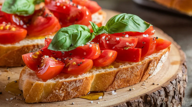 A slice of bread is topped with classic italian bruschetta with tomatoes and basil
