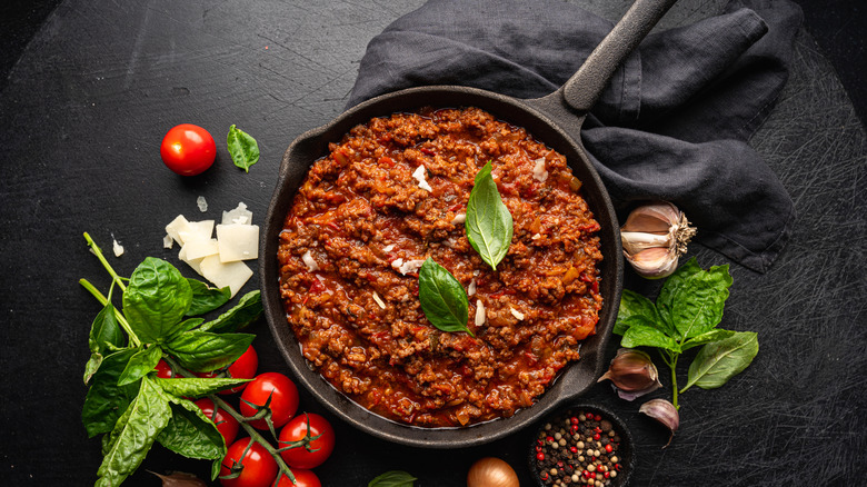 A classic Italian Bolognese sauce on a black surface.