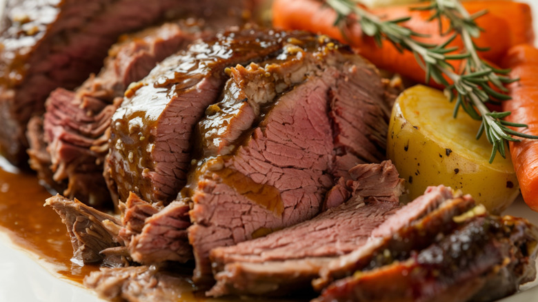 Sliced pot roast with potatoes, carrots, and herbs