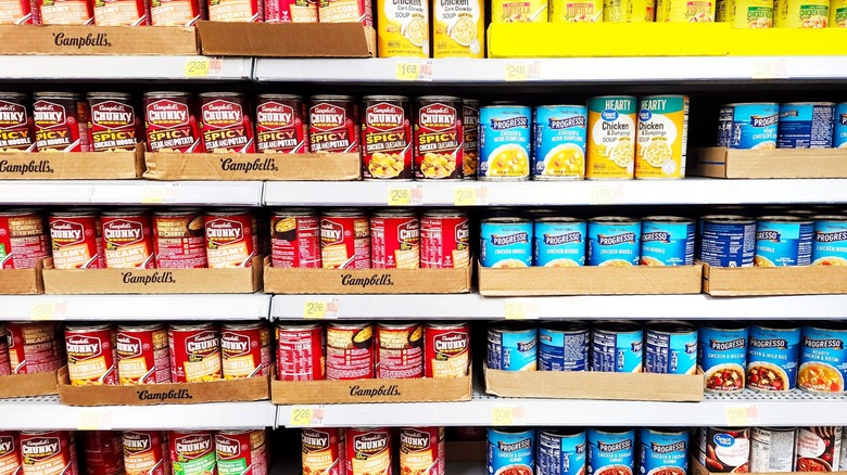 Rows of canned soup sit on shelves at the supermarket