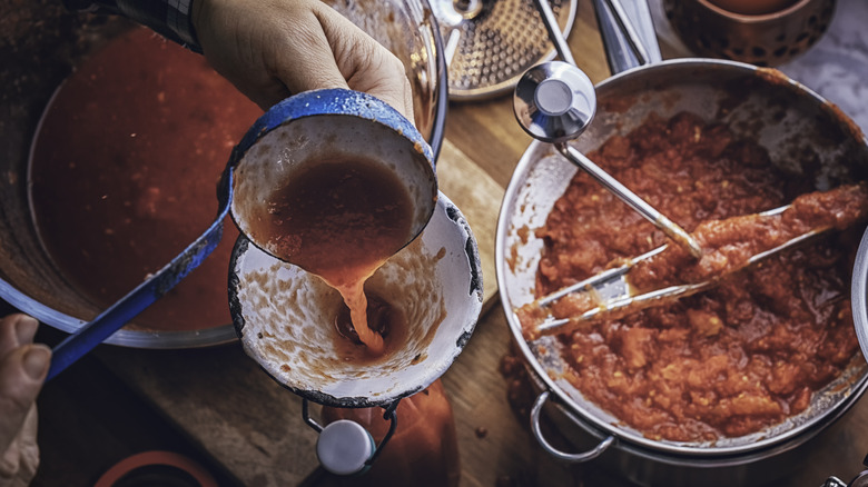 Person making tomato sauce