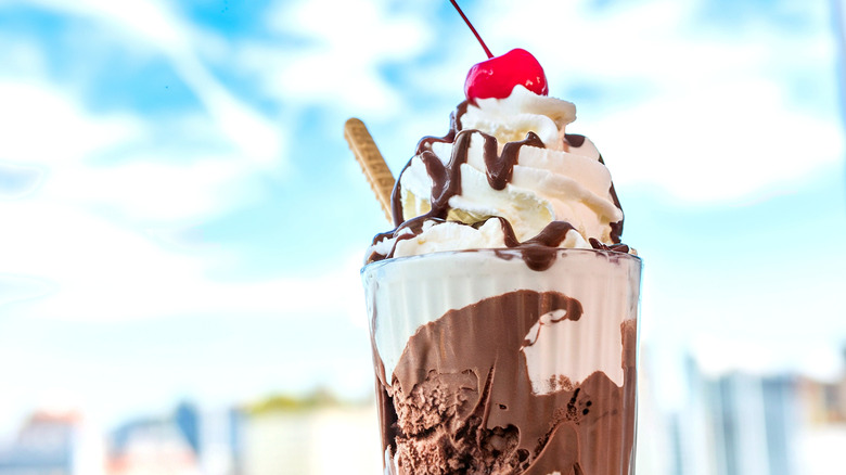 Close up of a vanilla and chocolate milkshake with a cherry