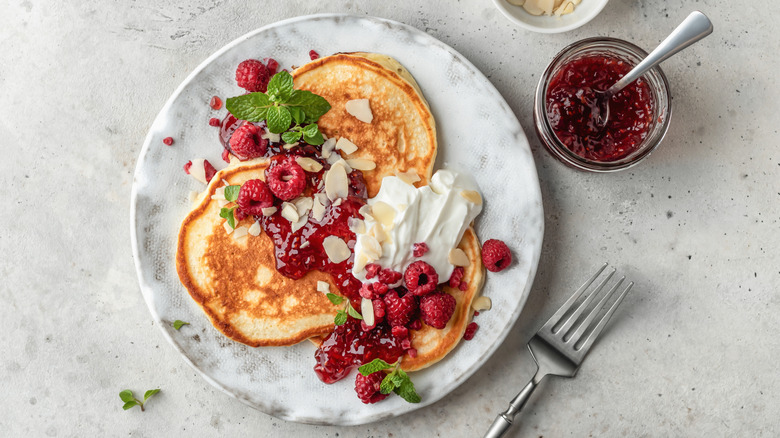 pancakes garnished with raspberries and yogurt