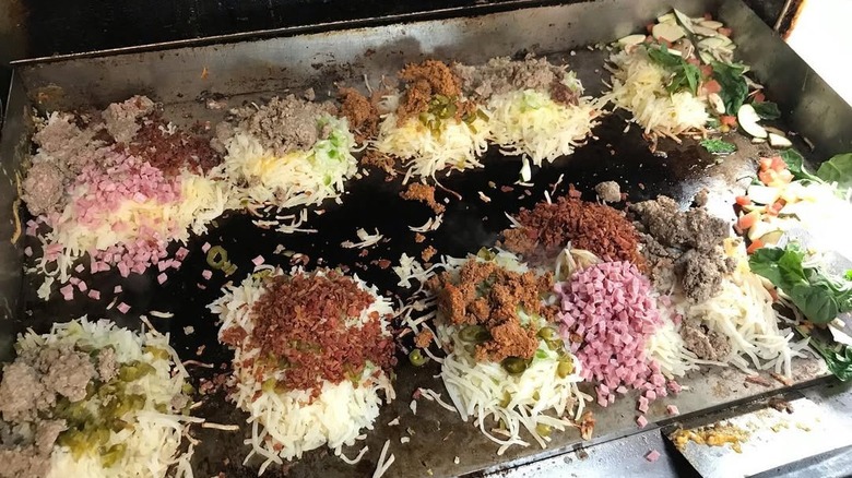 Griddle filled with individual piles of breakfast orders at Franks Diner in Kenosha