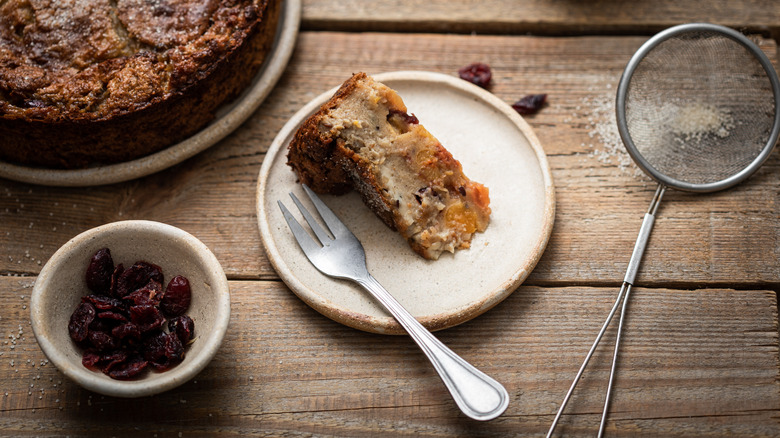Slice of a dense fruit cake with dried fruits and nuts