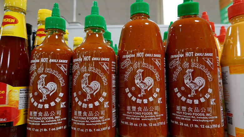Bottles of sriracha on the grocery store shelf