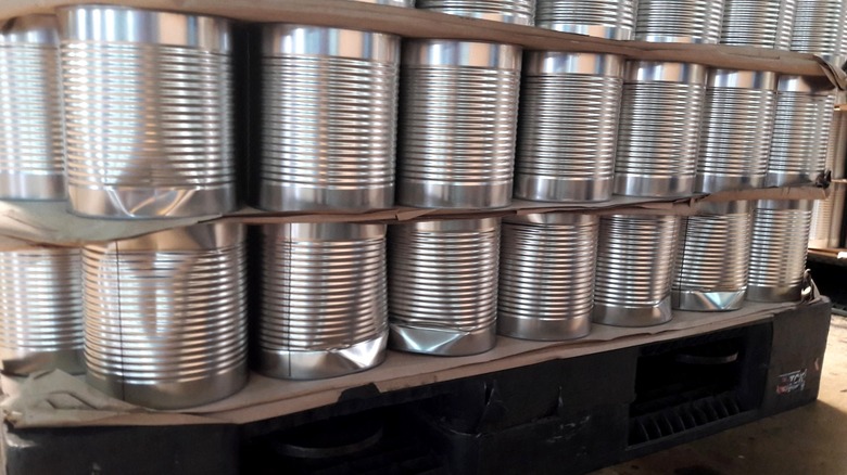 A pallet of swollen and dented food cans.