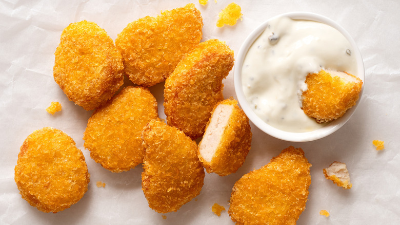 Chicken nuggets with a bowl of dip