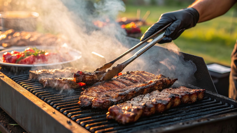 Grilling meat with tongs