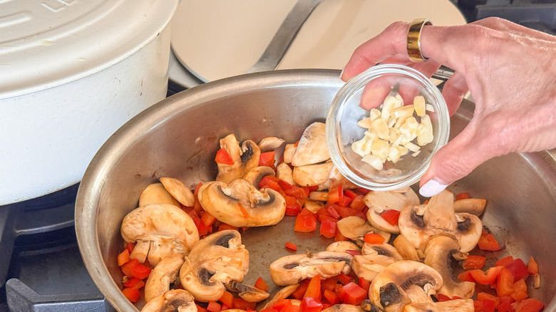 hand adding garlic