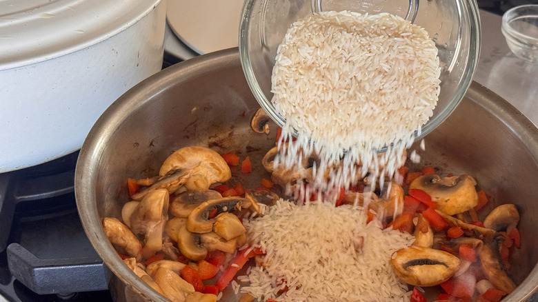 adding rice to pan