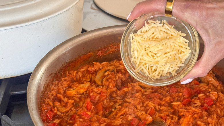 hand adding parmesan