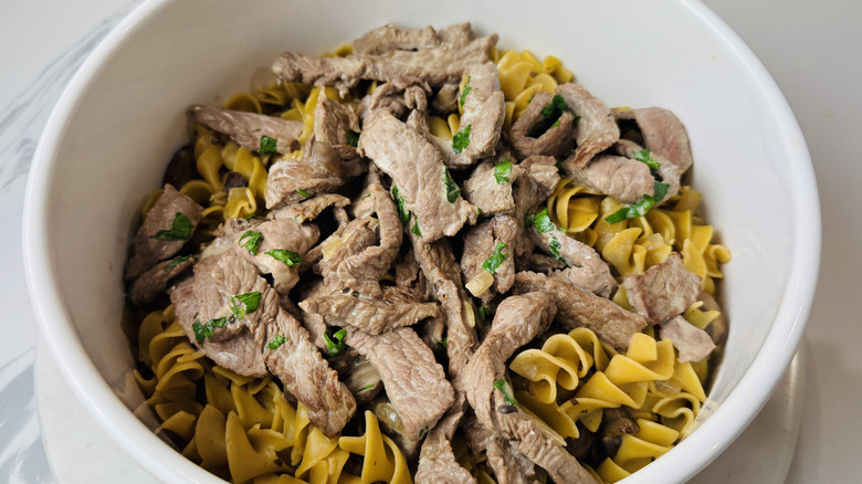 Egg noodles and steak strips in bowl