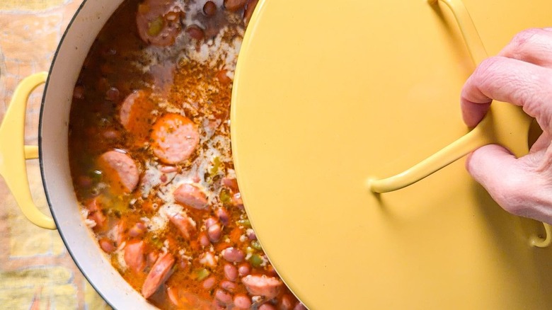Covering one-pot red beans and rice with yellow lid