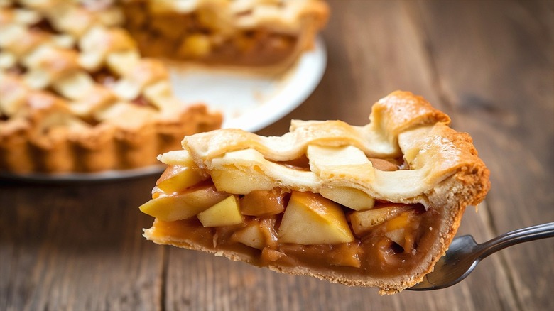 Slice of apple pie with lattice crust on serving utensil