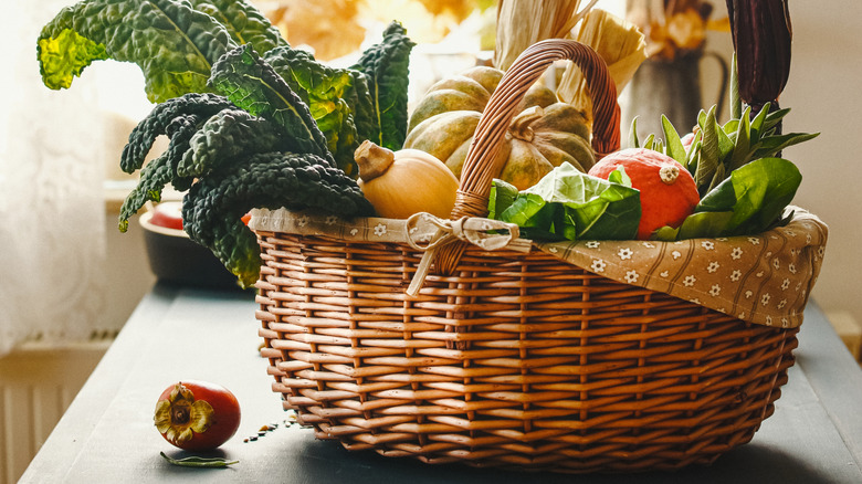 Fabric-lined basket filled with fall vegetables on a kitchen counter