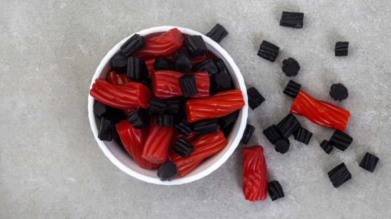Red and black licorice pieces in a white bowl