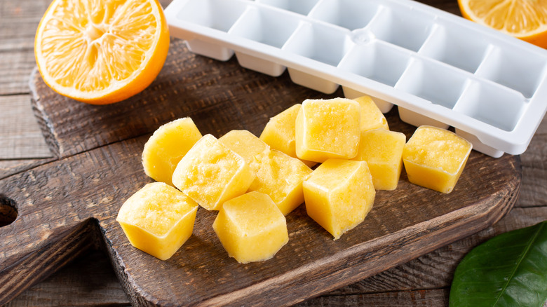 citrus juice ice cubes on wooden tray