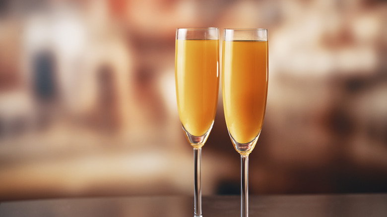 two mimosas in fluted glasses