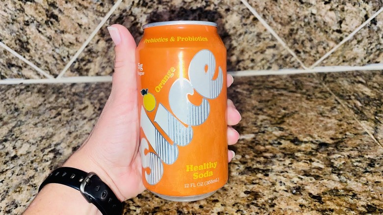 Hand holding can of Slice Orange Soda