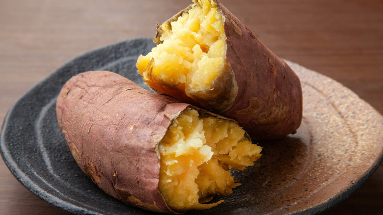 A roasted white sweet potato split in half on a plate