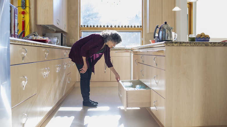 person opening kitchen drawer