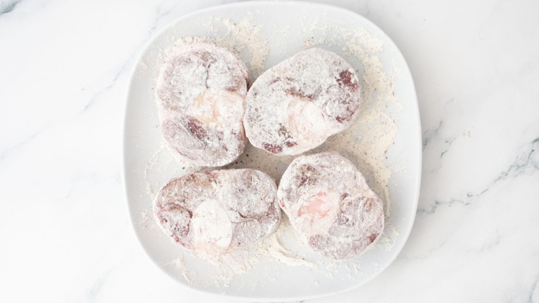Beef shanks coated in flour on plate