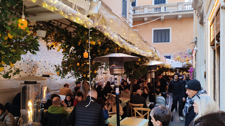 People pack into a cozy trattoria in an alleyway in Rome.
