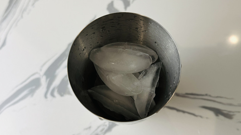 aerial view of ice in a cocktail shaker on marble surface
