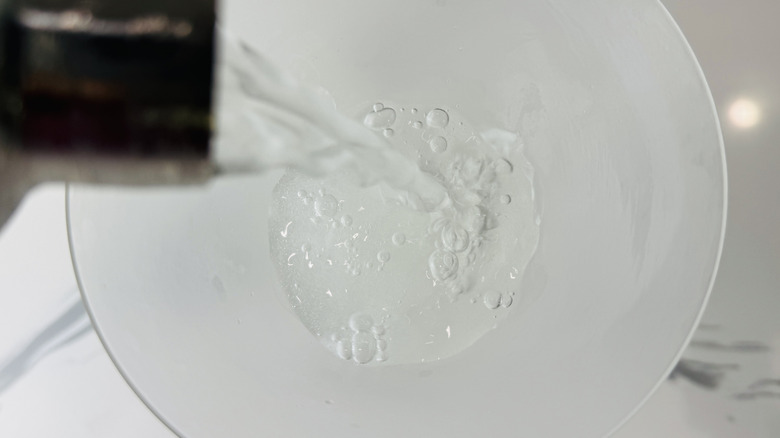 close up of martini pouring from shaker into glass cup